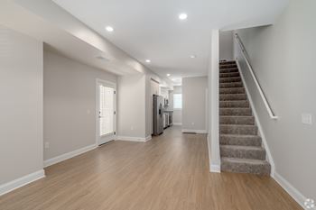 A spacious room with wooden floors and a staircase leading to another room. at Park Lamont Townhomes Apartments, Ohio, 44106